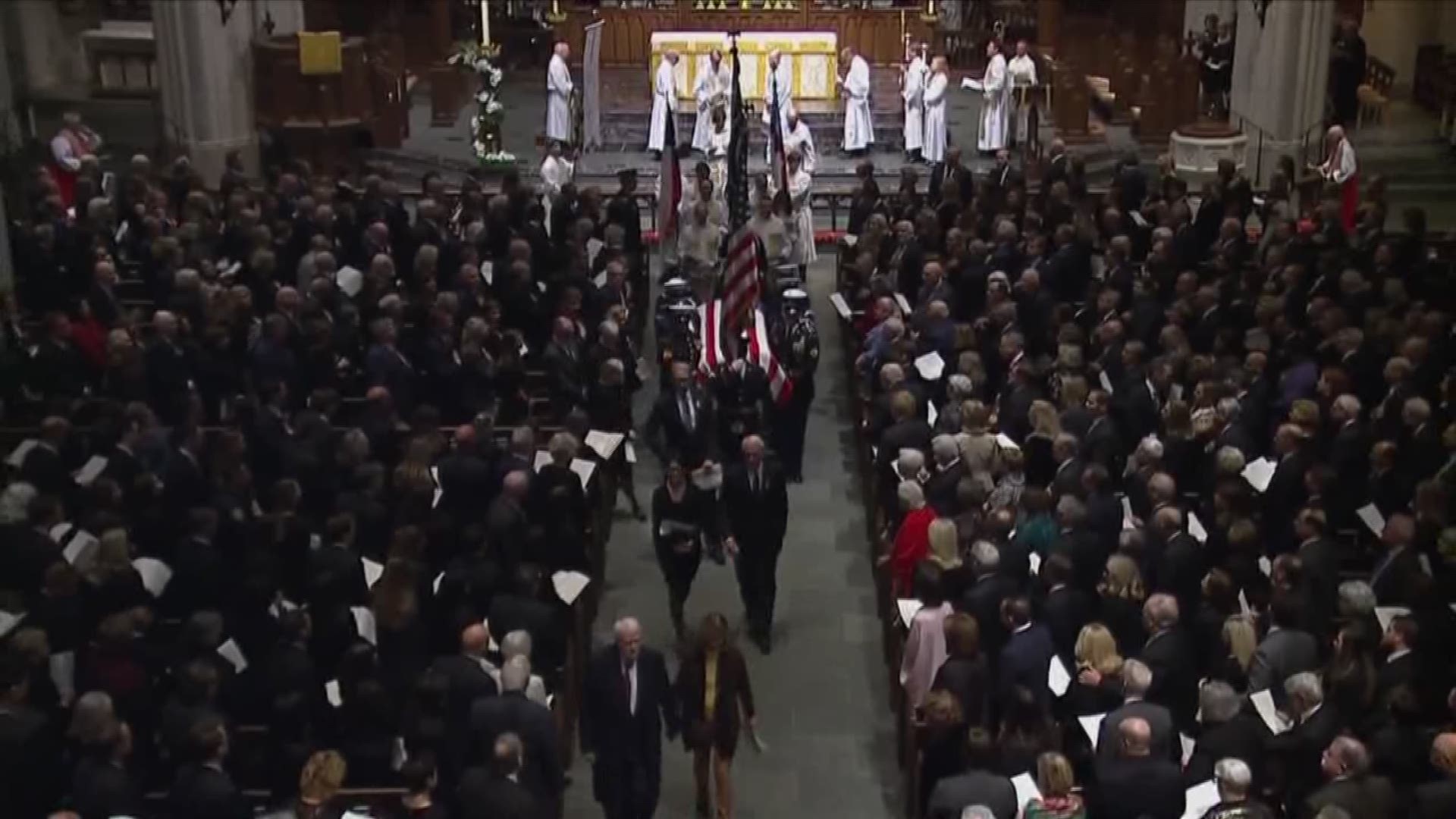Following funeral ceremonies, George H.W. Bush's casket is brought out of St. Martin's Cathedral in Houston, TX