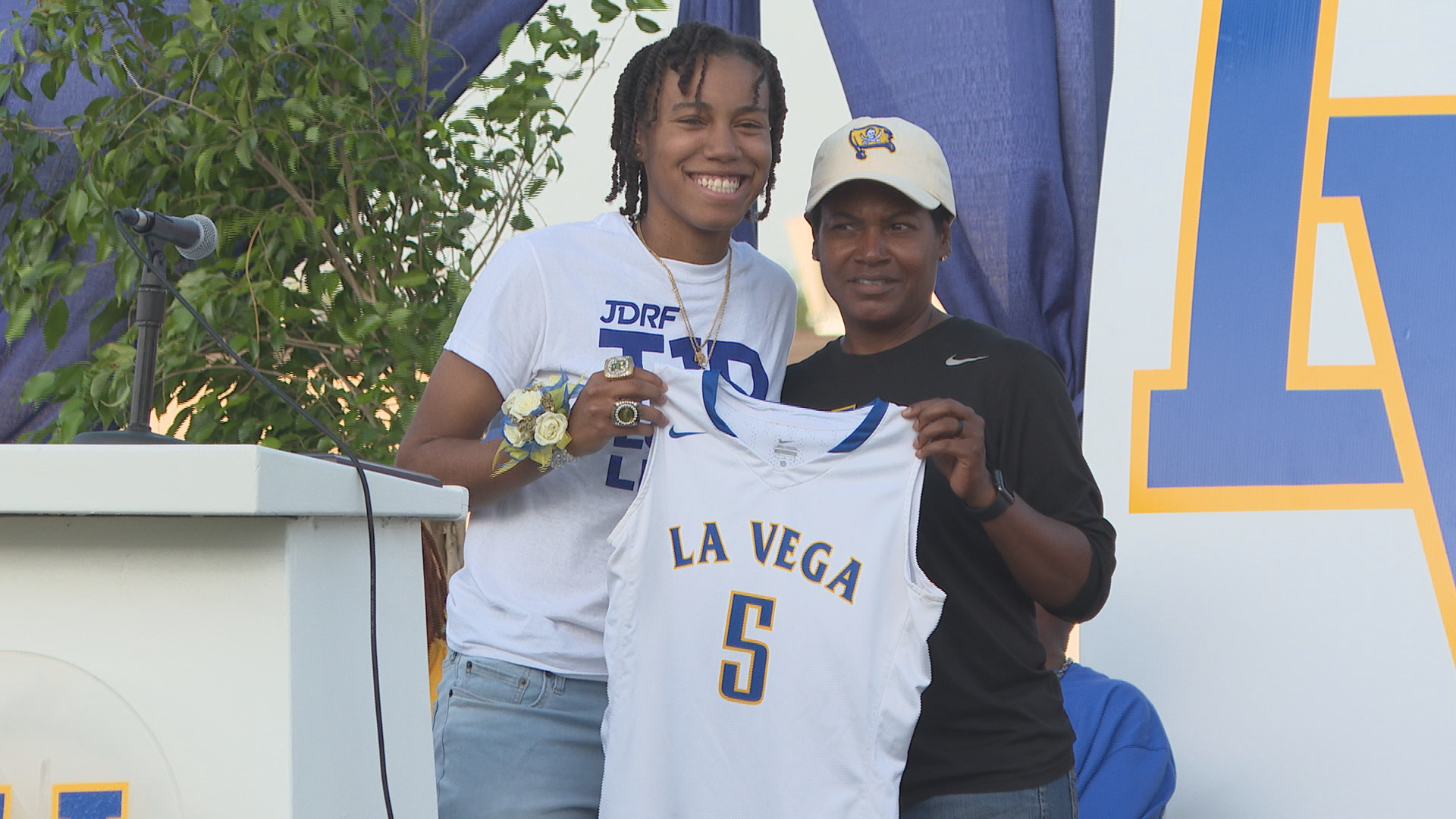 During La Vega High School's state championship parade for its track team, the school's former basketball star Juicy Landrum had her jersey retired.