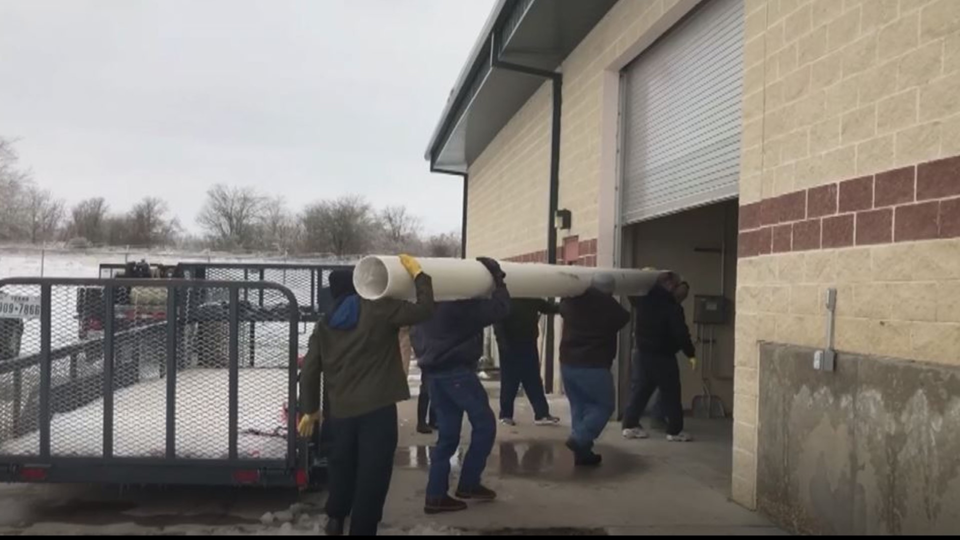 Community members helped with loading the heavy repair pipes and other materials that will be used to repair the water treatment plant.